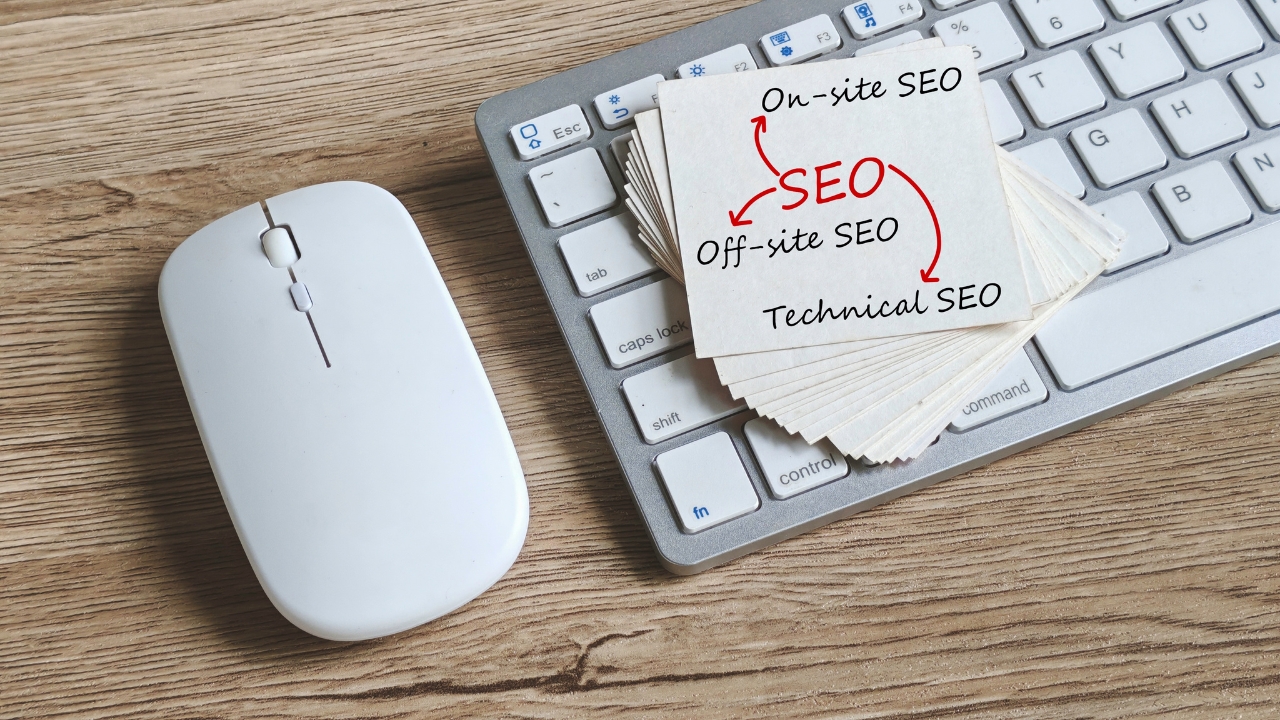 Kartice sa pojmovima SEO, on-site, off-site i tehnički SEO na tastaturi pored miša